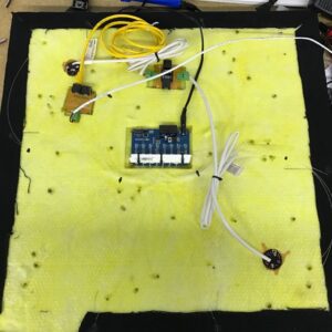 TopViewRear - WDM Lighting Prototype electronics mounted on yellow foam insulation with a blue control board and multiple connectors.